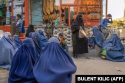 Aýallar hem çagalar Kabuldaky çörek kärhanasynyň öňünde mugt çöregiň paýlanmagyna garaşýarlar. 2021-nji ýylyň oktýabry