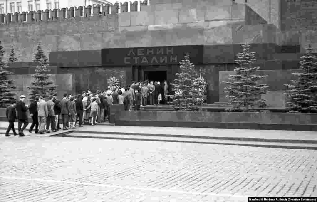 Посетители заходят в мавзолей Ленина и Сталина, август 1957 года После смерти Иосифа Сталина в 1953 году его тело забальзамировали и разместили рядом с телом Ленина. Над входом в мавзолей появилась вывеска с фамилиями двух советских диктаторов 