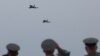 Military personnel watch as Eurofighter Typhoon jets fly over the newly rebuilt air base in Kucova, Albania, on March 4.