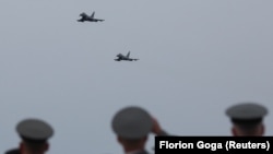 Military personnel watch as Eurofighter Typhoon jets fly over the newly rebuilt air base in Kucova, Albania, on March 4.