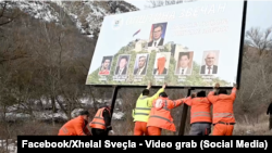 Kosovar authorities remove a billboard featuring pictures of Serbian President Aleksandar Vucic and Russian President Vladimir Putin, among others, in Zvecan, north Kosovo, on January 25.