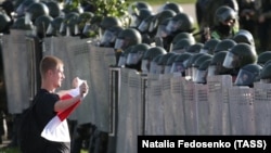A protester faces riot police during an anti-government demonstration in Minsk in September 2020.