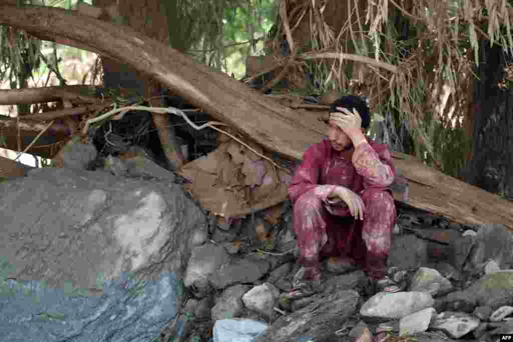An Afghan man sits near his house that was damaged in the floods, which also affected Kabul and other regions. 
