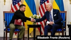 Ukrainian President Volodymyr Zelenskiy shakes hands with U.S. President Joe Biden in Paris on June 7.