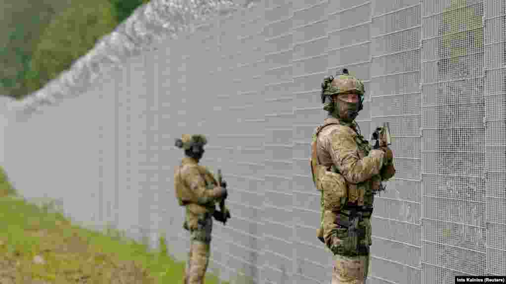 Latvian State Border Guard special unit officers patrol along the fence at the Belarusian border near Robeznieki. Riga has accused the Belarusian security forces of damaging the border fence and allowing four migrants to illegally cross in what it has referred to as &quot;another provocation.&quot;