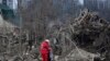 Медпрацівник заспокоює жінку посеред руїн будинків у Запоріжжі. Наслідки російської ракетної атаки. 22 березня 2024 року