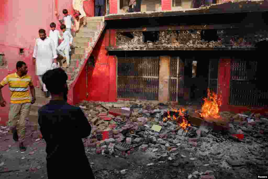 People gather at a church building vandalized by protesters.
