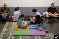 Izraelci sklonjeni u parking garažu tokom raketne uzbune, u Tel Avivu, Izrael, rano u utorak, 17. juna 2025.