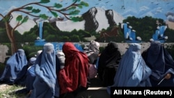 Owgan aýallary saud arabystanly ýardam topary tarapyndan paýlanýan azyklyk bukjalary kabul edip alýarlar. Aprel, 2022 ý. Kabul, Owganystan.