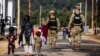 Military police walk past Afghan refugees at the Ft. McCoy U.S. Army base in Wisconsin in September.