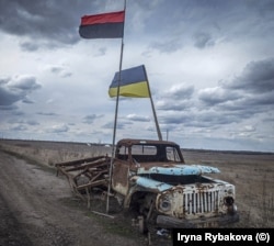 Украинский флаг и флаг украинской повстанческой армии (слева) на передовых позициях во время боёв между украинскими войсками и поддерживаемыми Россией сепаратистами в 2019 году