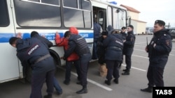 Полиция производит задержание предположительных нелегальных трудовых мигрантов на базаре «Садовод». Москва, 19 ноября 2013 года.