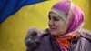 Ukraine - A Crimean Tatar woman stands by a Ukrainian flag as pro-Ukrainian demonstrators march in the streets of Simferopol in support of the Crimean Tatar community, on March 14, 2014