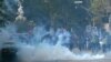 Policemen fire teargas canisters to scatter protesters during the march toward the U.S. consulate in Karachi on August 27.
