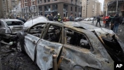 Rescue workers and investigators attend the aftermath of a Russian strike on Kyiv on December 20. 