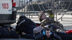 Ljudi se skrivaju dok se oglašava sirena za vazdušni napad, u blizini stambene zgrade oštećene nedavnim granatiranjem u Kijevu, Ukrajina, 26. februara 2022.