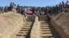 FILE: Graves prepared for the burial of civilians killed by insurgents at Mirza Olang village, in the northern Sar-e Pul province in August.