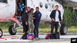 Anatoly Prytkov, one of the pilots of the An-28, is helped by his colleagues to exit a helicopter that was also carrying the other surviving passengers at an airport outside Tomsk.