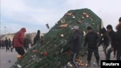 Участники протеста свалили новогоднюю елку на площади в Жанаозене. 16 декабря 2011 года.