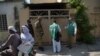 FILE: Officials from the Pakistan Bureau of Statistics collect information from a resident as Pakistani soldiers stand guard during the second phase of the national census in April.