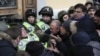 Міхеїл Саакашвілі (праворуч) спостерігає, як мітингувальники, яких він закликав йти до Жовтневого палацу, під час штурму будівлі виривають бійця Нацгвардії зі строю перед центральним входом до палацу. Київ, 17 грудня 2017 року