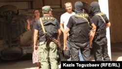 Бойцы специального отряда быстрого реагирования во дворе жителей поселка Шенгельды Алматинской области. 21 августа 2013 года.