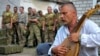 Український воїн грає на бандурі під час прощання із побратимами, які загинули у війні України з Росією. Місто Старобільськ Луганської області, 29 липня 2014 року (ілюстраційне фото)