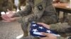 A U.S. soldier holds the national flag ahead of a handover ceremony at Leatherneck Camp in Lashkar Gah in Helmand, April 2017.