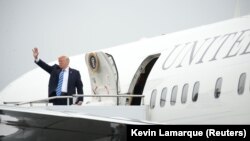 President Donald Trump waves while boarding Air Force One prior to departing Morristown Municipal Airport en route to Camp David, Maryland.