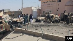 Afghan security personnel inspect the site of a previous suicide attack near police headquarters in Lashkar Gah, capital of Helmand Province, on August 23.