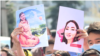 Protesters hold up pictures of Aizada Kanatbekova at a demonstration in Bishkek after her death.