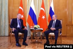 Владимир Путин слушает президента Турции Тайипа Эрдогана во время встречи в Сочи, Россия, 5 августа 2022 года