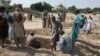 Mourners dig graves for the victims of a suicide blast outside the Sufi shrine in Jhal Magsi district in Balochistan on October 6.