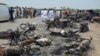 Pakistan -- People gather behind burnt motorcycles and vehicles at the scene of an Oil tanker accident on the outskirts of Bahawalpur, June 25, 2017