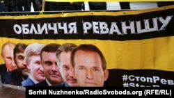 Плакат із зображенням українських олігархів і президента Росії Володимира Путіна під час акції «Стоп Реванш» біля Верховної Ради України. На акції вимагали ухвалення низки законів, спрямованих на боротьбу з російською агресією. Київ, 16 січня 2018 року (ілюстраційне фото)