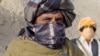 Taliban spokesman Zabiullah Mujahid speaks to a journalist in the mountains of Helmand Province last month.