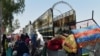 FILE: Afghan refugee families gather next to their belongings at the United Nations High Commissioner for Refugees (UNHCR) repatriation center on the outskirts of Peshawar in April.