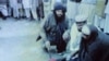 Pakistan -- Image taken from the Pakistani private Dawn News channel on 04Apr2009, shows a burqa-clad woman face down on the ground being held by her arms and feet by three men while a man flogs her in Swat valley.
