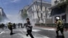 A demonstrator flees from Greek riot police during a protest in Athens on May 11. Thousands of Greeks took to the streets amid a new raft of government austerity measures designed to forestall a costly debt overhaul.