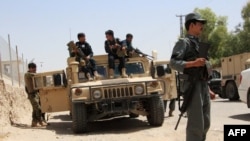 Afghan soldiers sit on an armored vehicles during a battle with the Taliban militants in Helmand's Gereshk district on July 22.