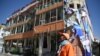 An Afghan municipality worker looks on in front of a damage wedding hall building near the site of a car bomb attack in western Kabul on July 24.