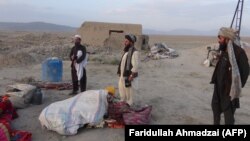 Afghan men gather at the site of an airstrike in Dasht-e-Bari village in Logar province near Kabul on August 30.