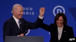 U.S. Vice President Kamala Harris (right) and President Joe Biden hold hands at the Democratic National Committee 2023 Winter meeting in Philadelphia, Pennsylvania, in February 2023.