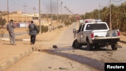Iraqi police inspect the site of militant attack in the town of Haditha on March 5.