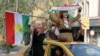 Iraqis Kurdish women celebrate with the Kurdish flag as they ride outside the windows and roof of a taxi in the northern city of Kirkuk on September 25, 2017 as they voted in a referendum on independence.
